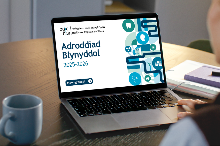 Person yn darllen Adroddiad Blynyddol AGIC 2025-2026 ar liniadur